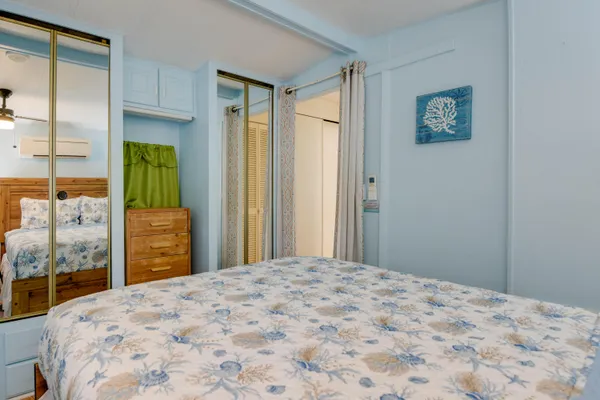 a bedroom with a bed and a dresser next to a window