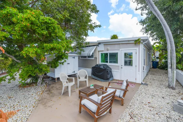 a view of a backyard with table and chairs and a large tree