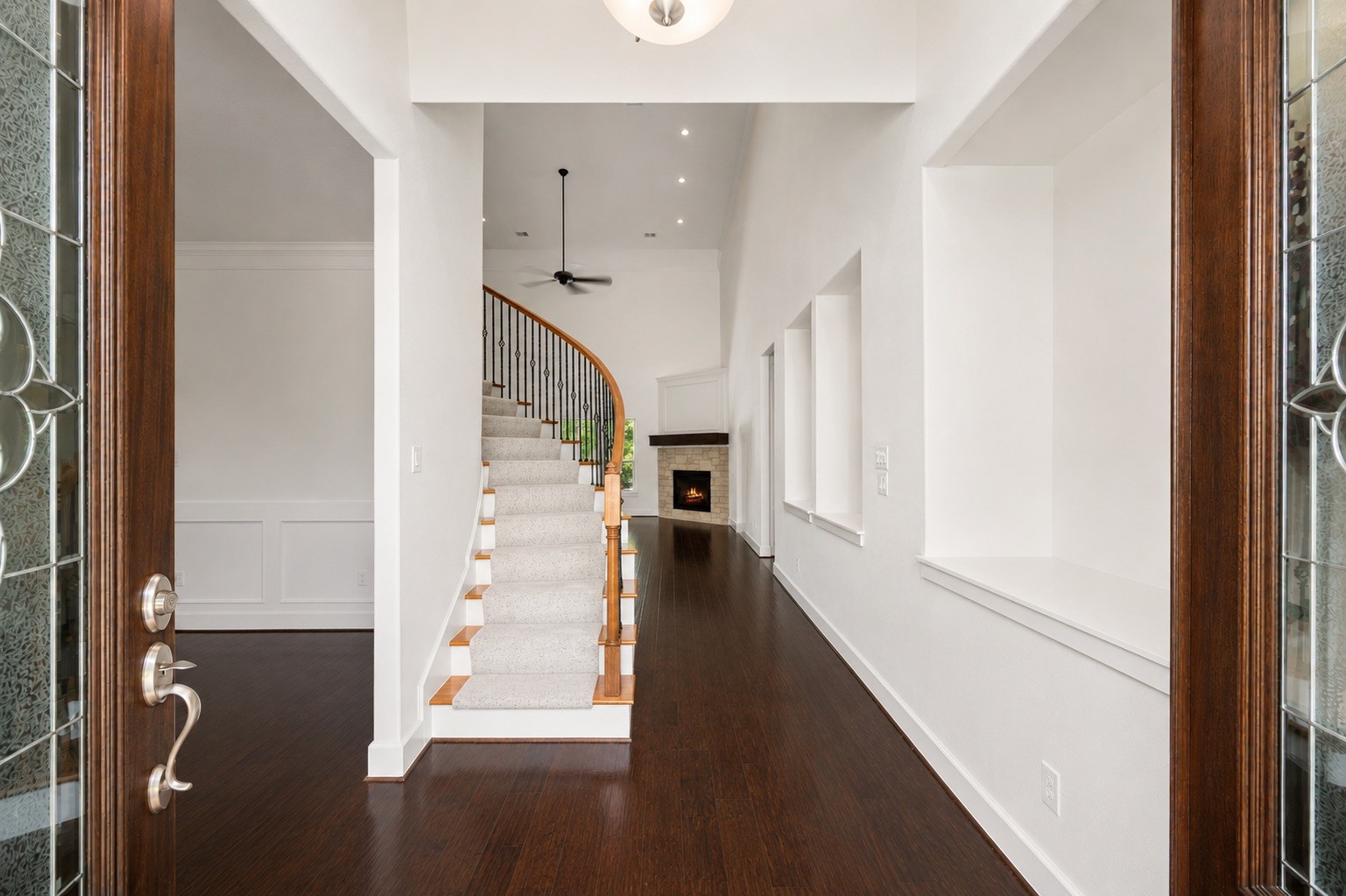 1904 Boulder Ridge Drive Conroe, TX 77304 - Photo 6 of 37 Step through the gorgeous double doors into a breathtaking foyer! This dramatic entryway boasts rich hardwood floors, towering high ceilings, and a sweeping curved staircase that immediately sets a luxurious tone for the rest of the home.