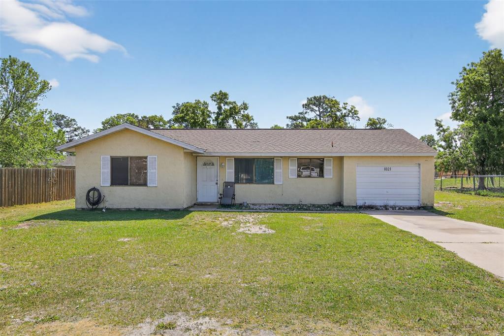 a view of a house with a yard and a tree