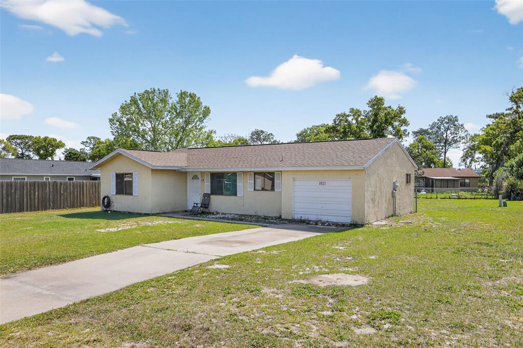 8821 Southeast 89th Place Ocala, FL 34472 - Photo 2 of 30 a view of a house with a yard and a large tree