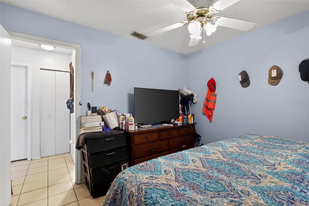 8821 Southeast 89th Place Ocala, FL 34472 - Photo 21 of 30 a bedroom with a bed and a flat screen tv