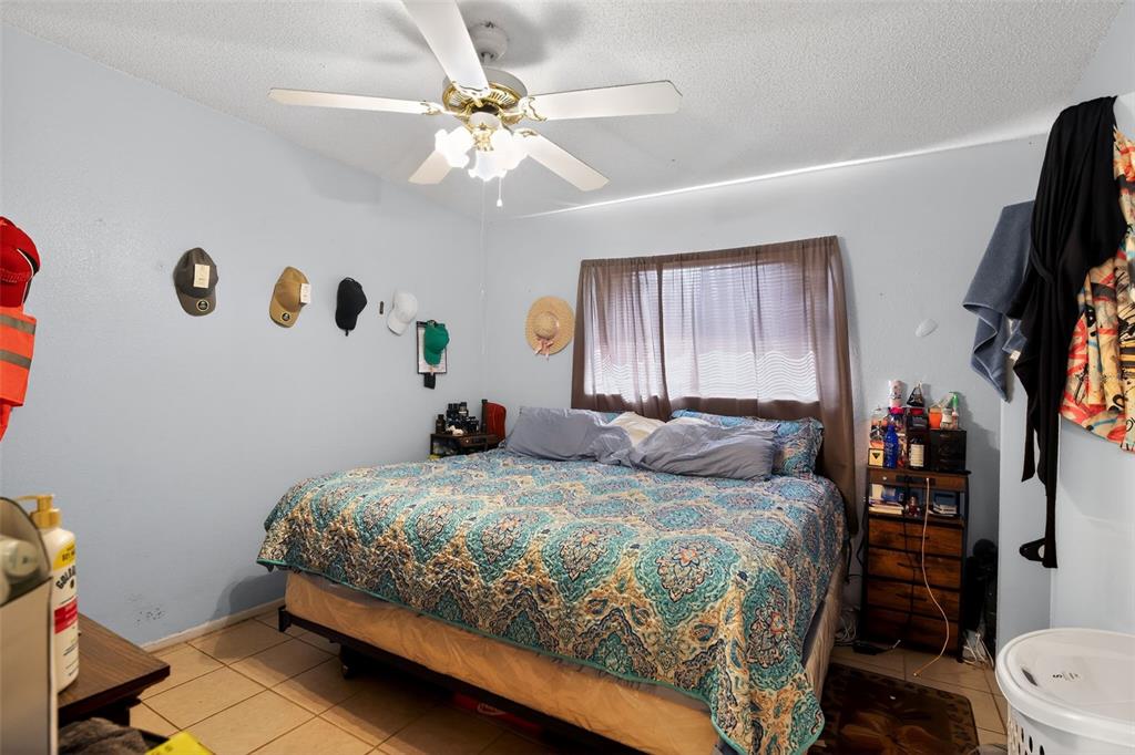 8821 Southeast 89th Place Ocala, FL 34472 - Photo 24 of 30 a bedroom with a bed and a chandelier