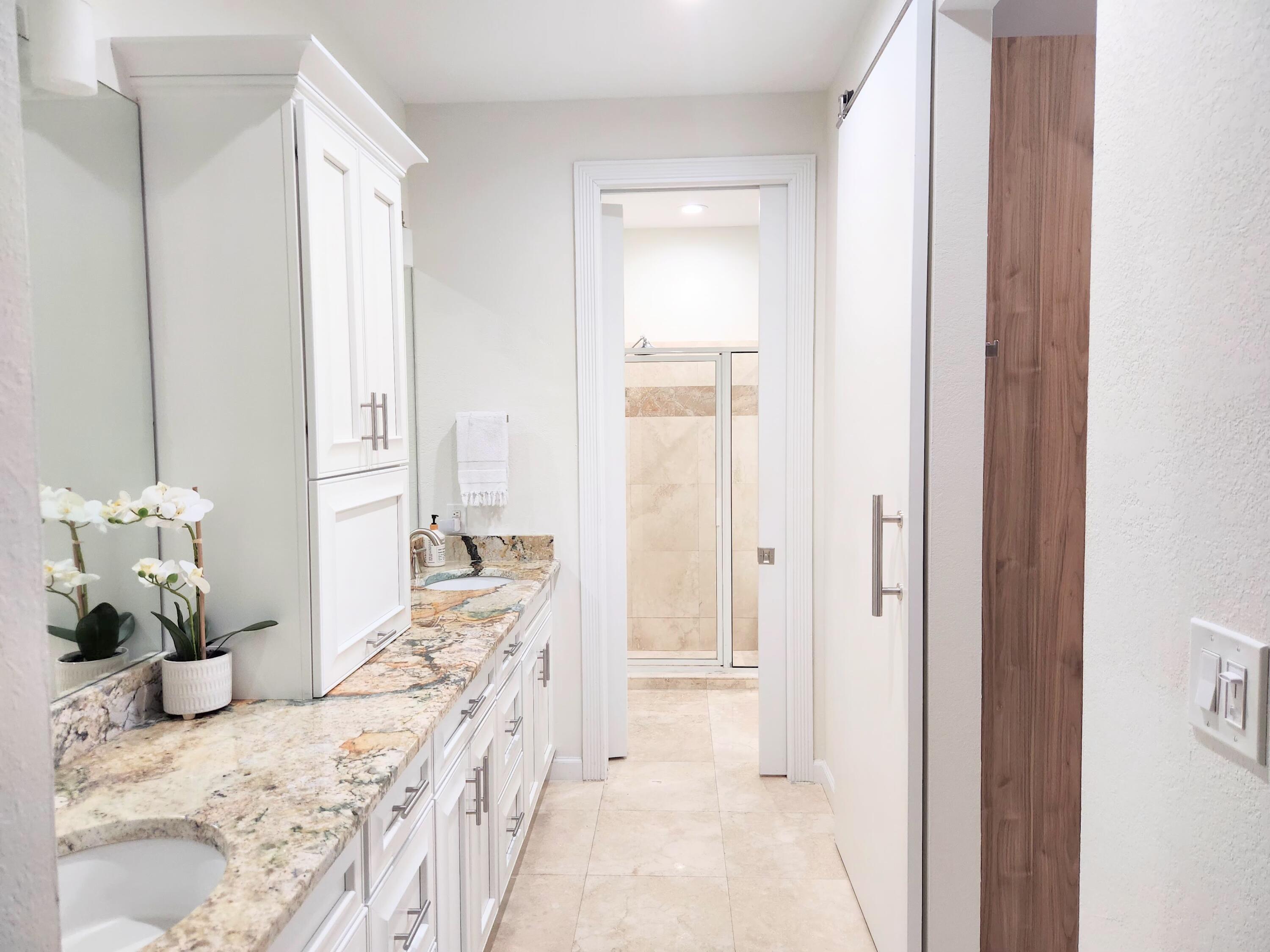 3567 Commodore Circle Delray Beach, FL 33483 - Photo 31 of 76 a bedroom with a bed and a chandelier