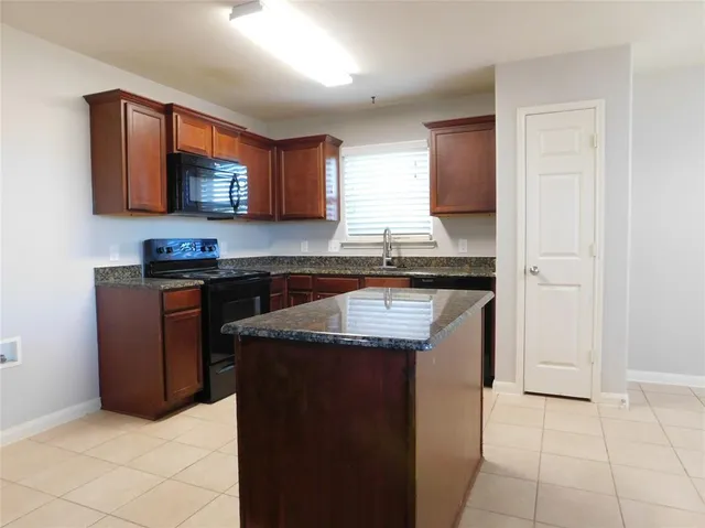 a kitchen with stainless steel appliances granite countertop a sink stove and cabinets