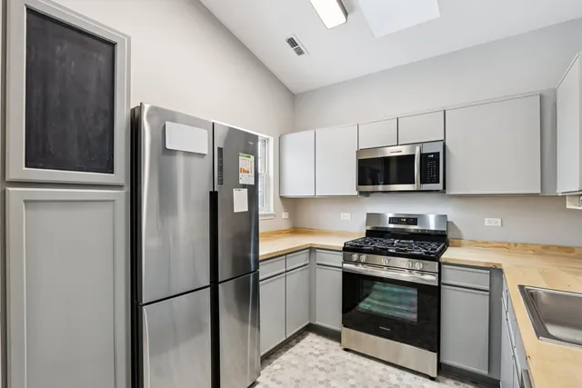 a kitchen with stainless steel appliances granite countertop a refrigerator stove a microwave and cabinets