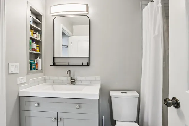 a bathroom with a toilet sink and mirror