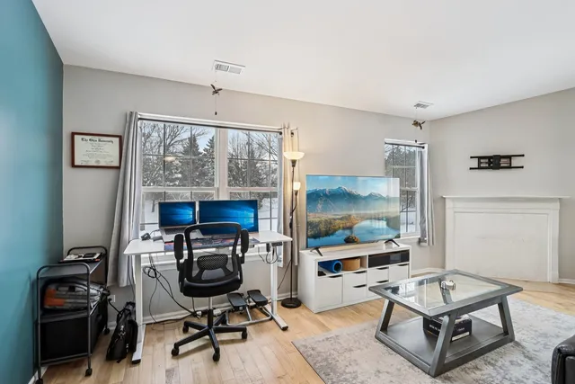 a living room with furniture a flat screen tv and a window