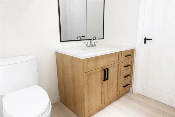 a bathroom with a sink a toilet and mirror