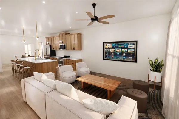 a living room with furniture kitchen view and a window