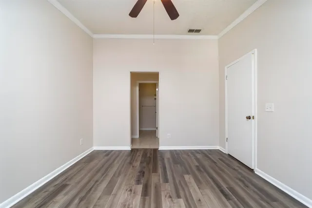 a view of an empty room with wooden floor