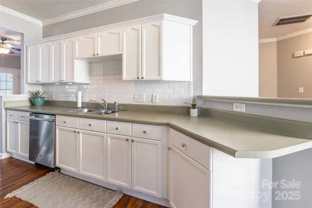 a kitchen with white cabinets white appliances sink and window