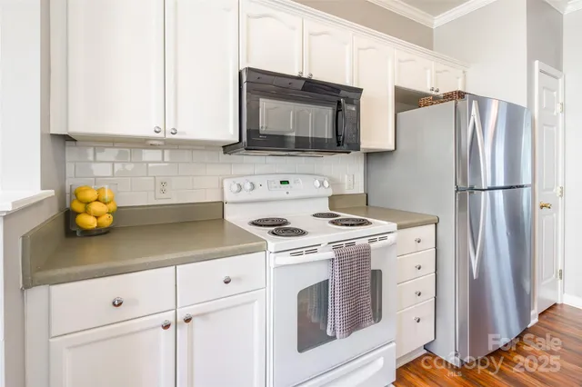 a kitchen with stainless steel appliances white cabinets and a stove top oven