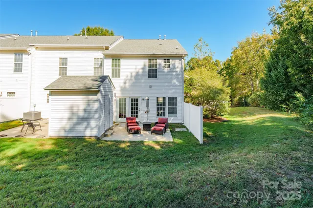 a view of a house with backyard and sitting area