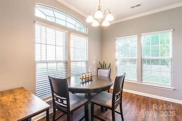 a view of a dining room with furniture wooden floor and chandelier