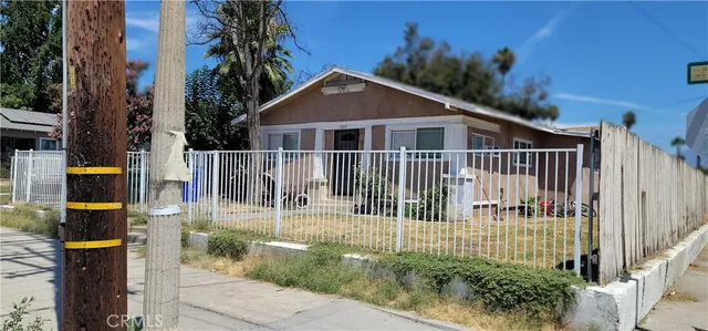 a view of a house with a small yard and potted plants