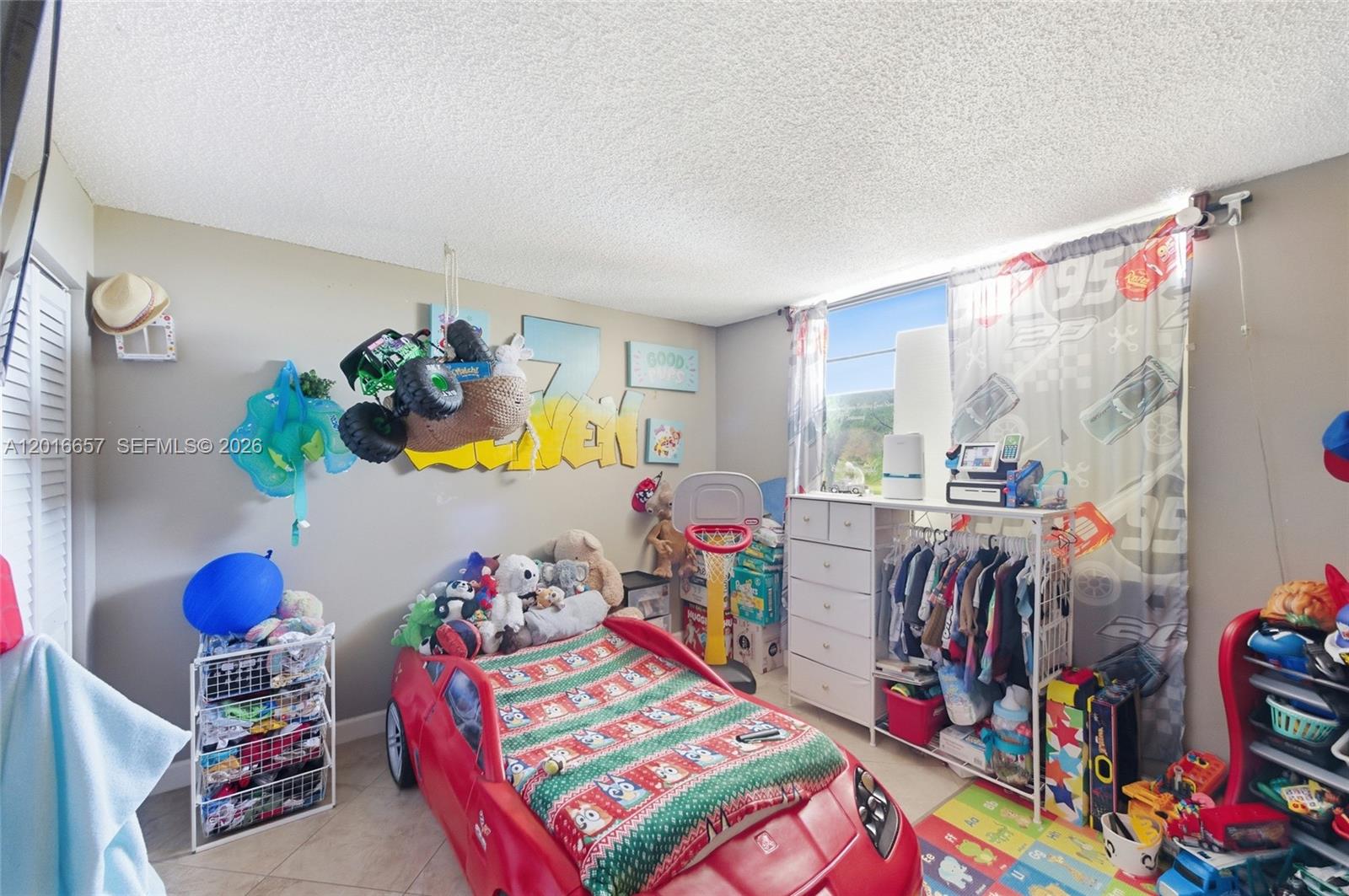 6195 Rock Island Road, Unit 511 Tamarac, FL 33319 - Photo 18 of 31 a bed room with a bed and a book shelf