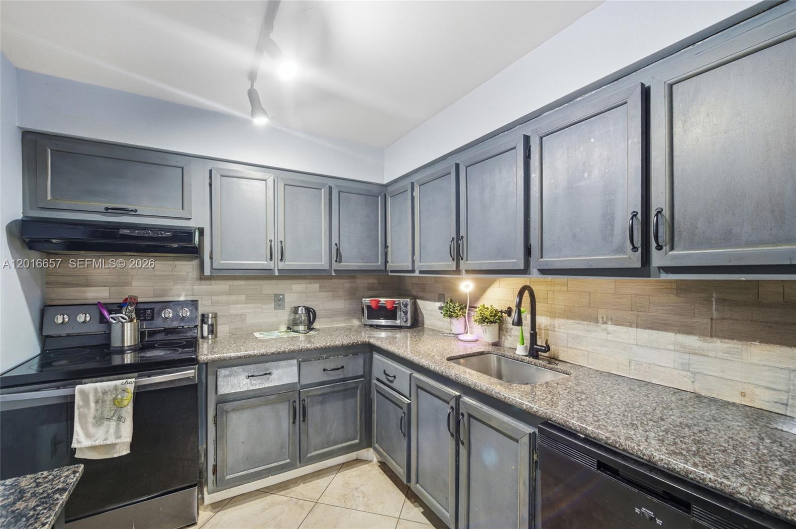 6195 Rock Island Road, Unit 511 Tamarac, FL 33319 - Photo 2 of 31 a kitchen with stainless steel appliances granite countertop a sink stove and cabinets