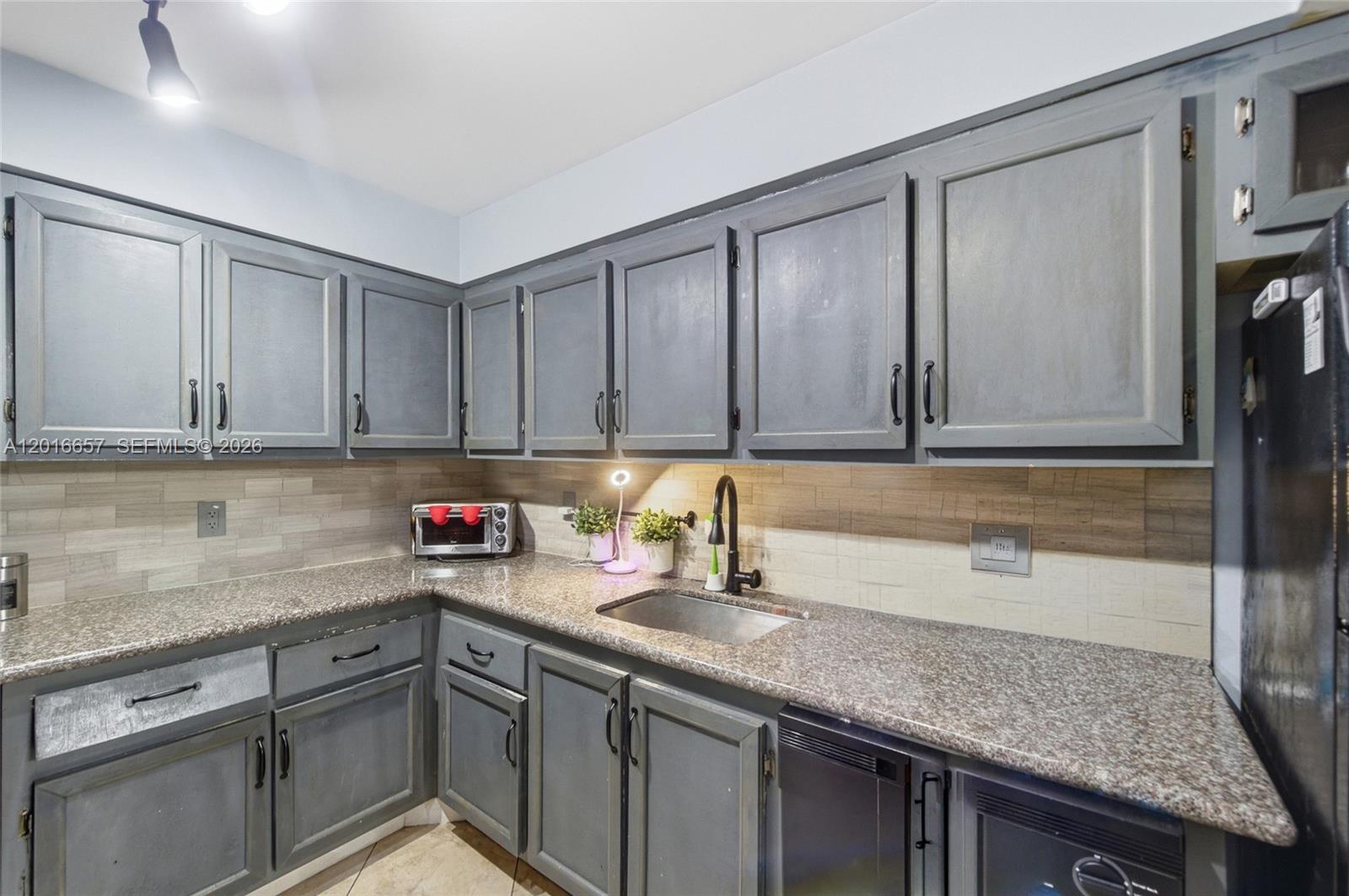 6195 Rock Island Road, Unit 511 Tamarac, FL 33319 - Photo 5 of 31 a kitchen with stainless steel appliances granite countertop a sink a stove and cabinets