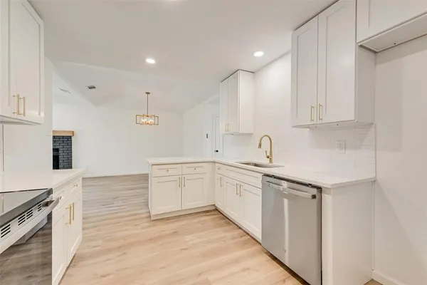 a kitchen with granite countertop a sink and white cabinets