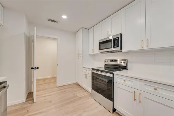 a kitchen with stainless steel appliances granite countertop a stove and a microwave