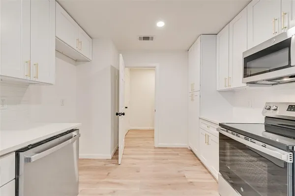 a kitchen with stainless steel appliances granite countertop a stove and a microwave