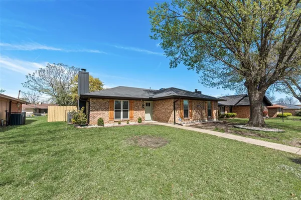a view of a house with a big yard and large tree