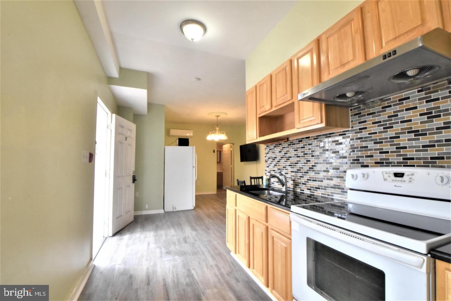1224 Summer Street, Unit 1 Philadelphia, PA 19107 - Photo 3 of 6 a kitchen with granite countertop a stove and cabinets