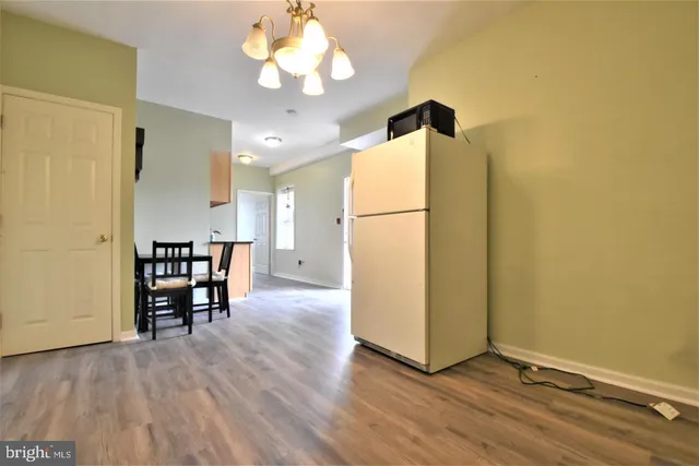 a view of a room with wooden floor and a ceiling fan