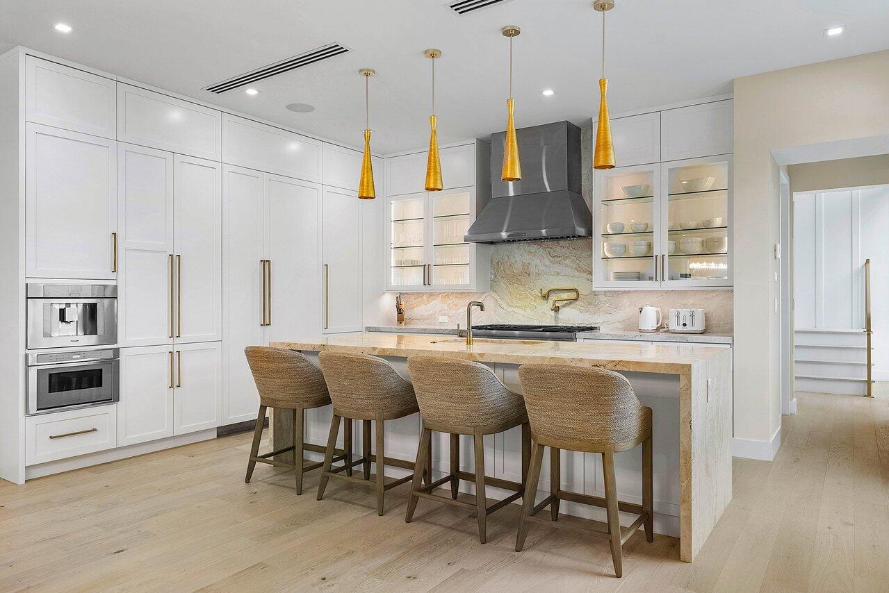 909 Bond Way Delray Beach, FL 33483 - Photo 13 of 43 a kitchen with stainless steel appliances granite countertop a table chairs sink and cabinets