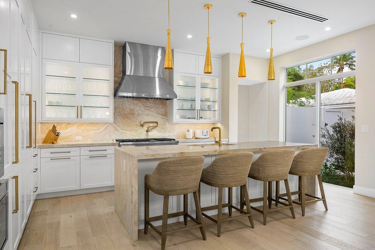 909 Bond Way Delray Beach, FL 33483 - Photo 14 of 43 a kitchen with granite countertop white cabinets stainless steel appliances and view of living room