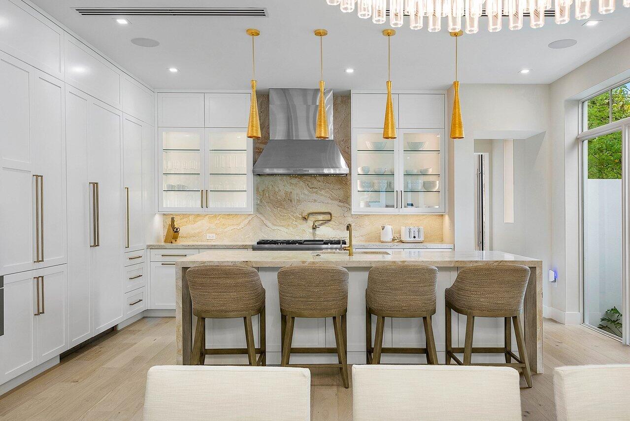 909 Bond Way Delray Beach, FL 33483 - Photo 15 of 43 a kitchen with stainless steel appliances granite countertop a table chairs sink and cabinets