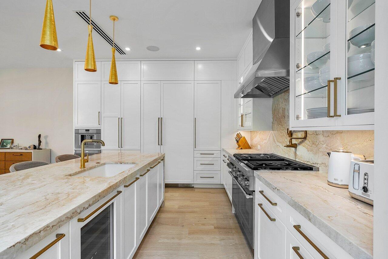909 Bond Way Delray Beach, FL 33483 - Photo 16 of 43 a kitchen with stainless steel appliances granite countertop a stove and a sink