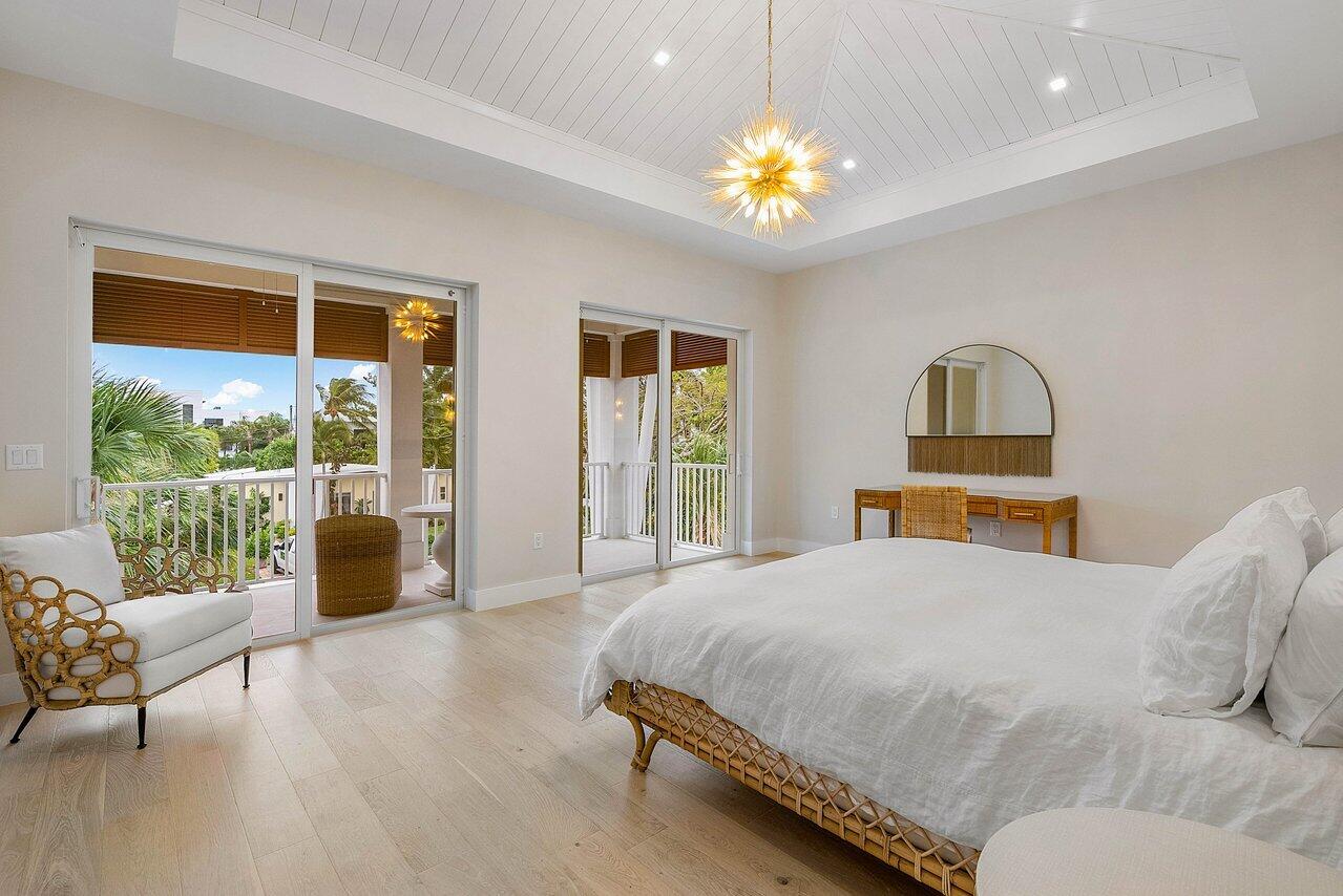909 Bond Way Delray Beach, FL 33483 - Photo 25 of 43 a bedroom with a large bed and a chandelier