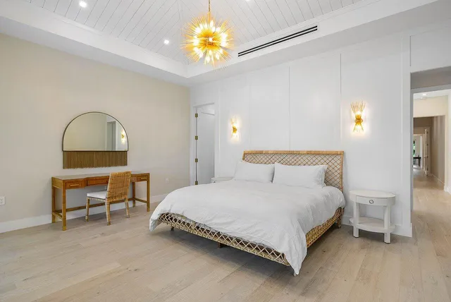 a bedroom with a bed table and a chair