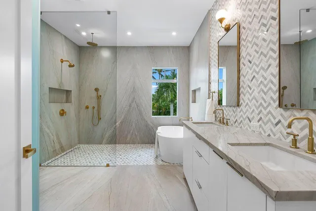 a spacious bathroom with a granite countertop sink a mirror a bathtub and shower
