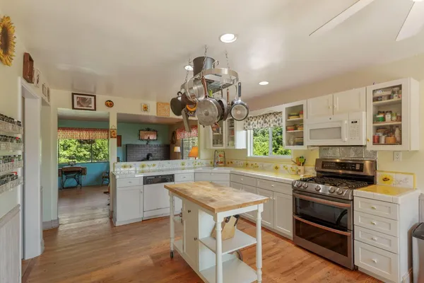 a kitchen with a stove cabinets and wooden floor