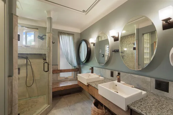 a bathroom with a double vanity sink mirror and bathtub