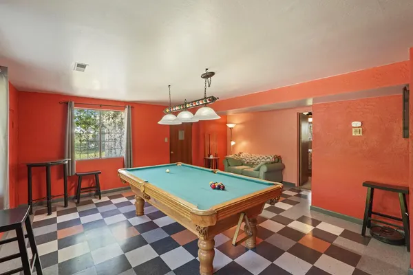 a room with pool table and a chandelier