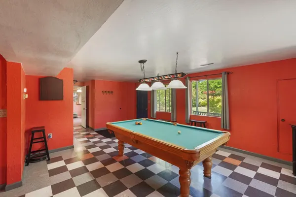 a room with pool table and windows