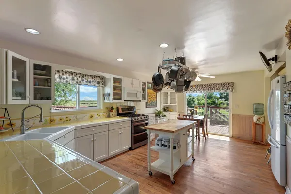 a kitchen with a table chairs a stove a dining table and chairs