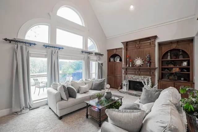 a living room with furniture a large window and a chandelier