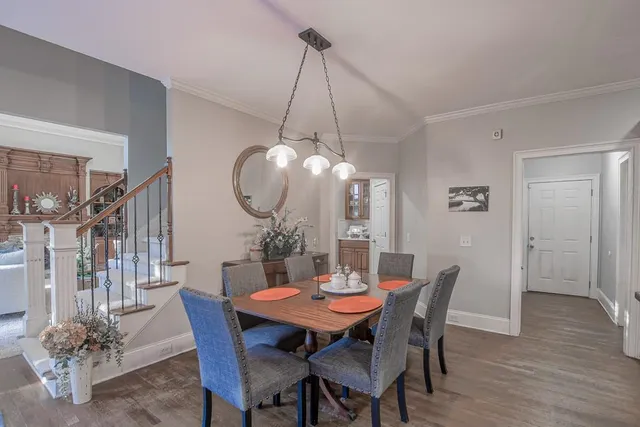 a view of a dining room and livingroom with furniture wooden floor a chandelier