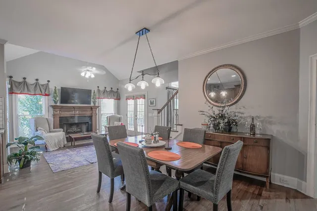 a kitchen with stainless steel appliances granite countertop a table chairs sink refrigerator and cabinets