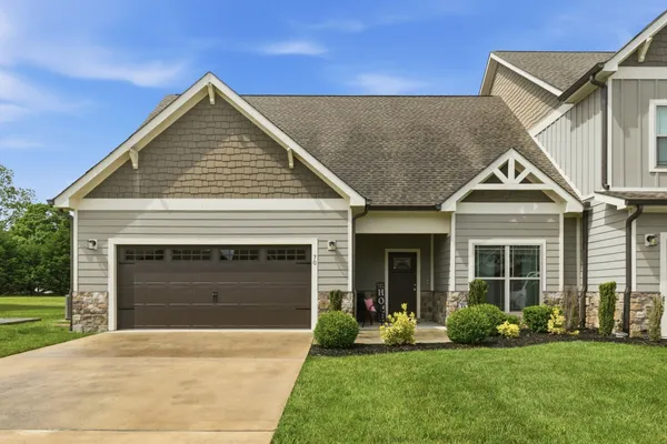 a front view of a house with a yard and garage