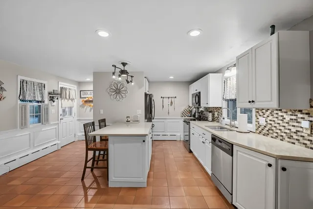 a large white kitchen with a sink and dishwasher