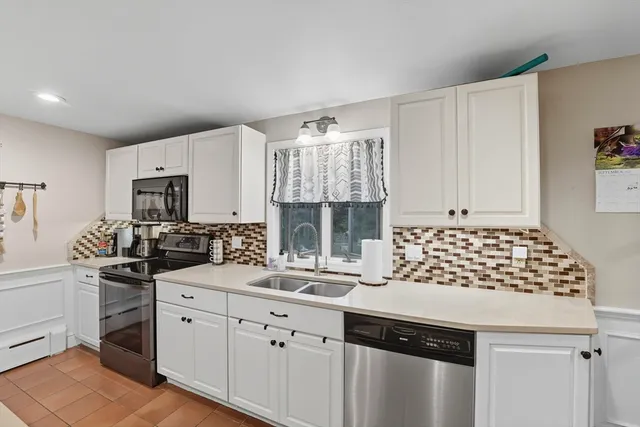 a kitchen with granite countertop a sink stainless steel appliances and cabinets