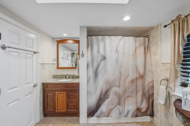 a bathroom with a granite countertop sink a vanity and a shower
