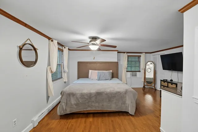 a bedroom with a bed and a flat tv screen on dresser