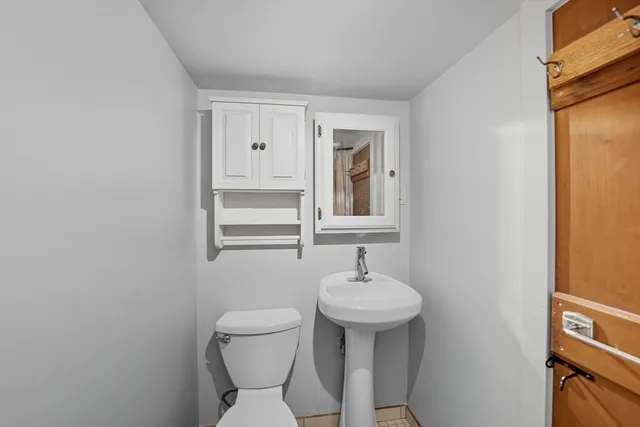 a bathroom with a sink toilet and mirror
